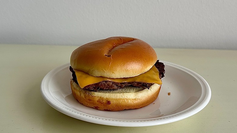 IHOP's cheeseburger on a small white plate in front of a neutral background