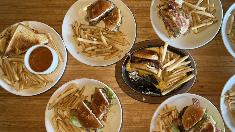 8 plates of Applebee's hamburgers with fries.
