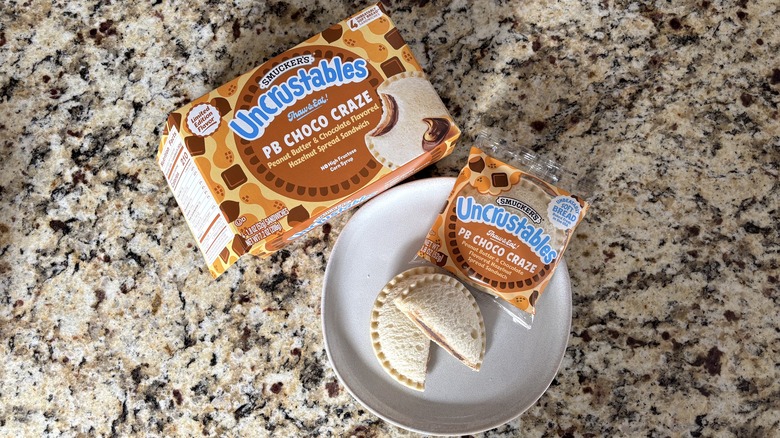 PB choco craze Uncrustables in box, package, and on plate on marble countertop