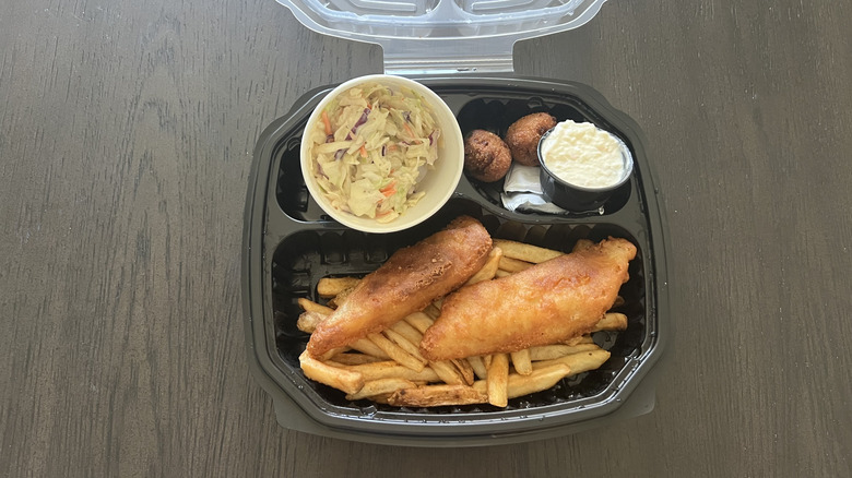 Red Lobster Fish and Chips in to-go plastic container with coleslaw, sauce, hushpuppies, fries, and two fish fillets