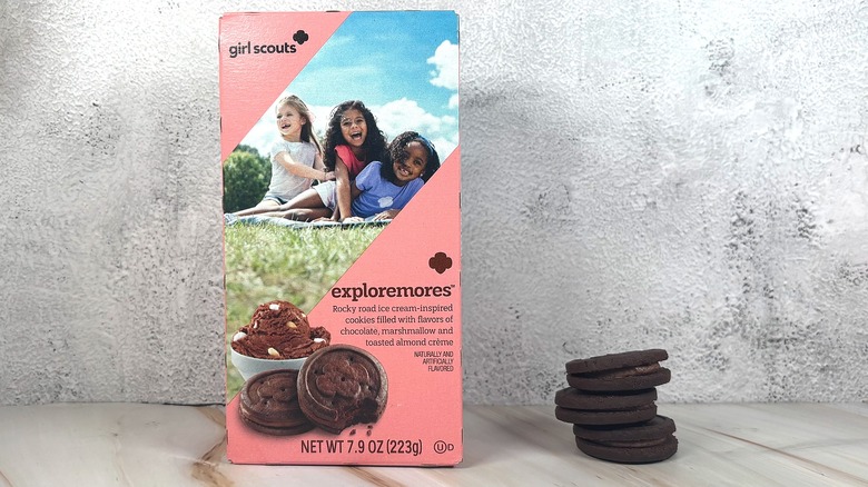 Box of Girl Scouts Exploremores next to stack of three cookies