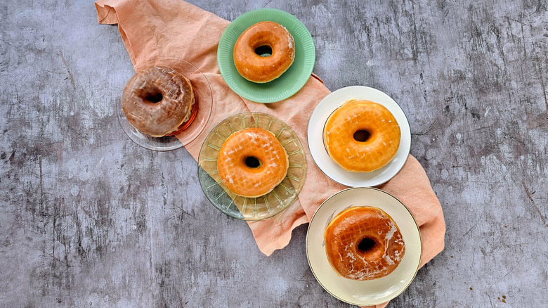 Five glazed donuts on plates