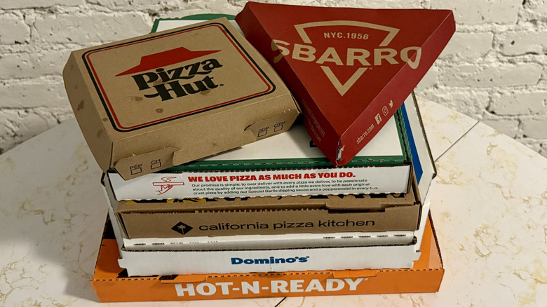 Stack of assorted chain pizza boxes