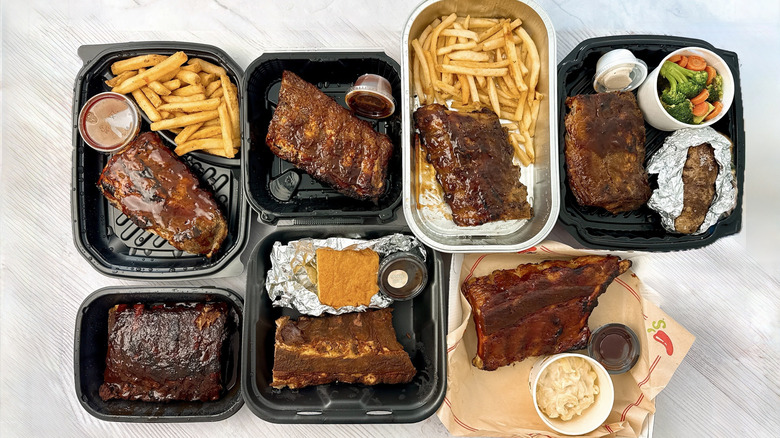 Seven containers of restaurant ribs and sides