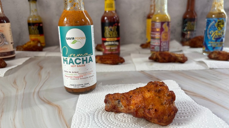 Savir Foods Crema Macha hot sauce on table next to chicken wing