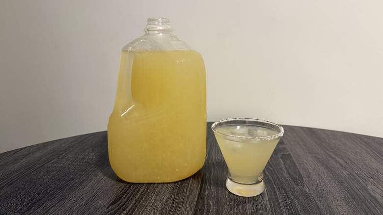 Gallon of margarita next to a glass