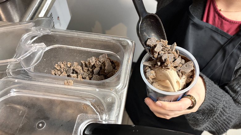 Scooping Girl Scouts Thin Mints cookie chunks onto a Frosty Fusion