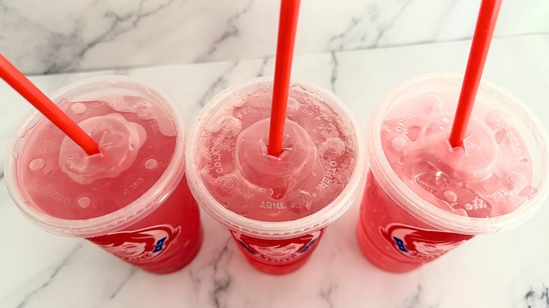 Top-down shot of three Wendy's watermelon drinks on marble surface