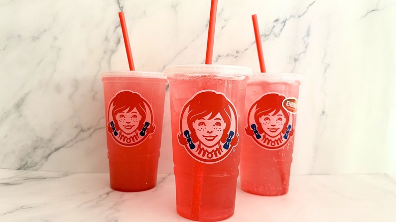 Three Wendy's watermelon drinks in triangle on marble surface