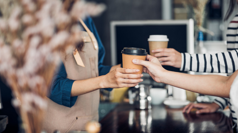 Barista handing customers coffees