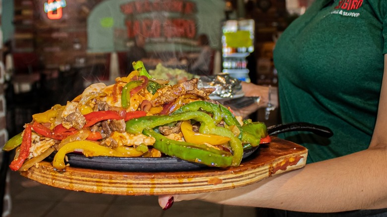 Close-up of a Taco Giro server holding a platter of Mexican food