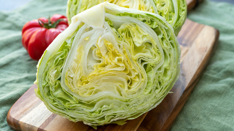 A fresh iceberg lettuce on a chopping board