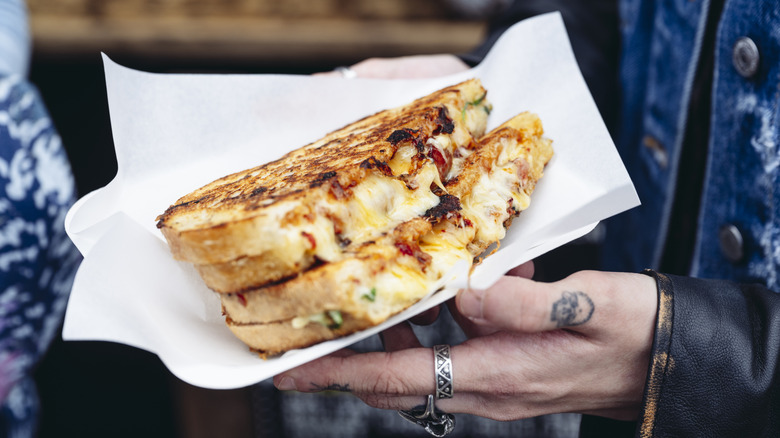 Grilled cheese held by hands
