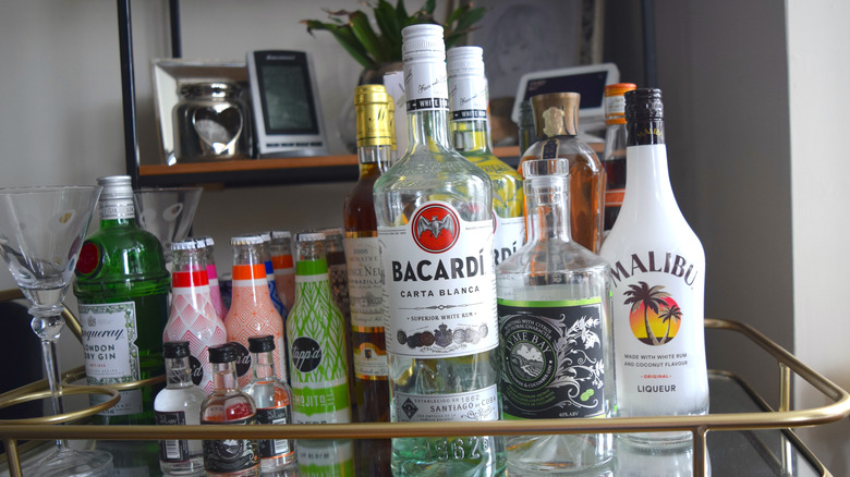 Liquor cart with bottles of Bacardi, Malibu, Tanqueray, and mixers