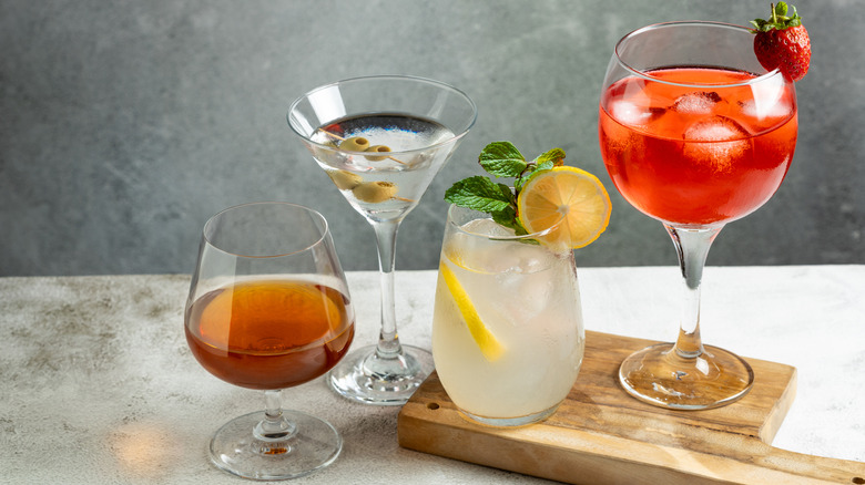 Various cocktails on a wooden serving tray.