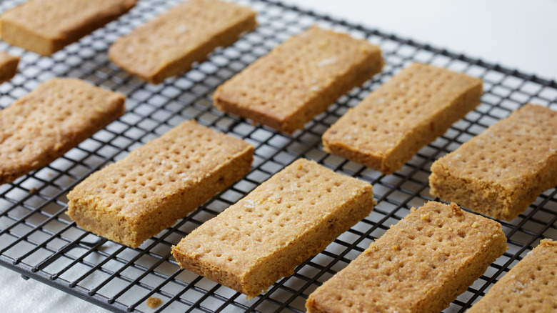 A rack of cut shortbread cooling on a kitchen counter