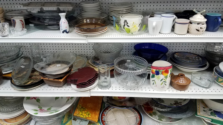 Dishes scattered on thrift store shelves