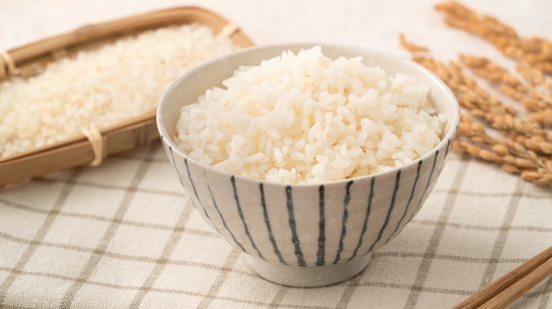 bowl of cooked rice with grains in background
