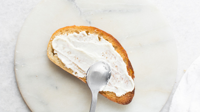 mayo being spread on piece of bread