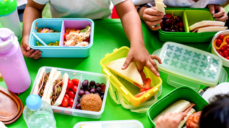 an overhead view of children eating lunch at a green plastic table
