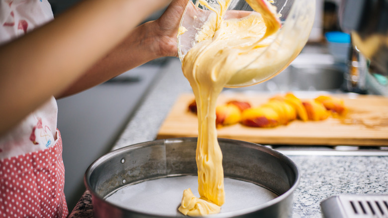 Woman pouring batter into cake pan