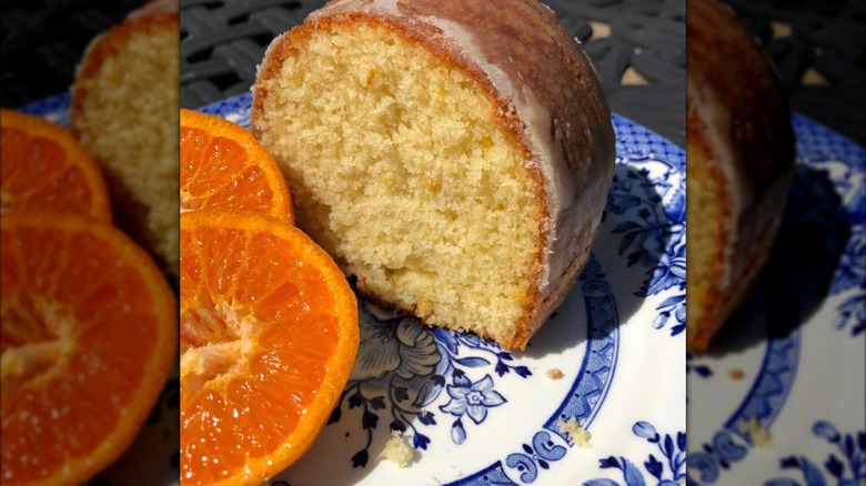 Slice of cake and orange halves on plate