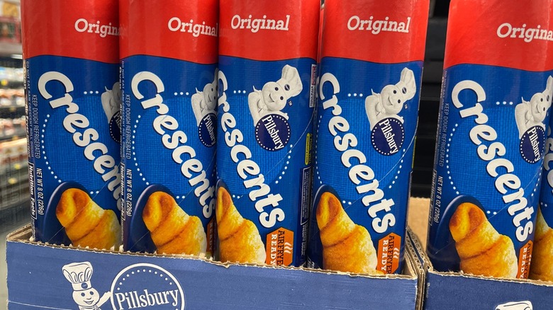 Pilsbury Crescent rolls in cans on a store shelf.