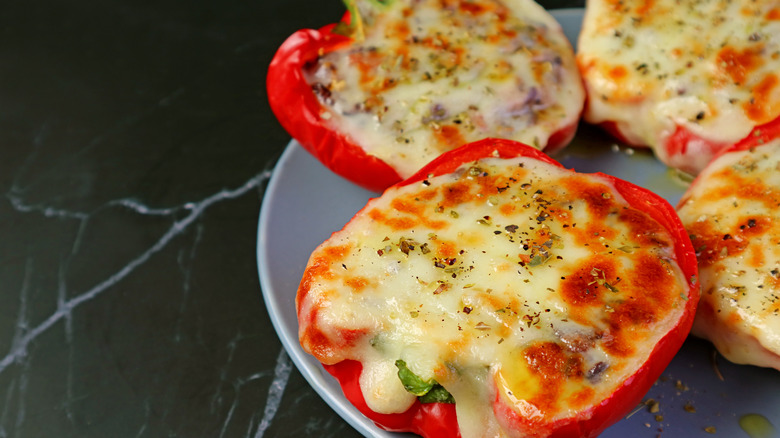 A close-up of cheesy stuffed bell peppers on a blue plate