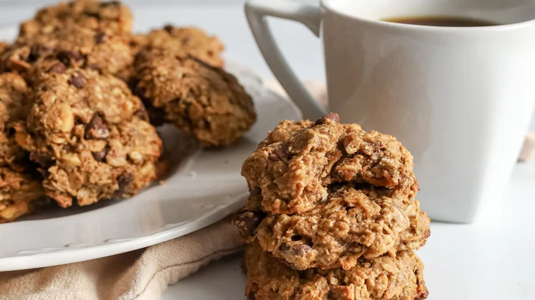 Freshly baked cookies on plate beside mug