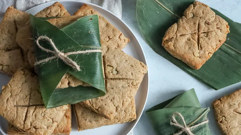 A plate of Lembas bread with its top square wrapped in a banana leaf placed beside loose Lembas breads.