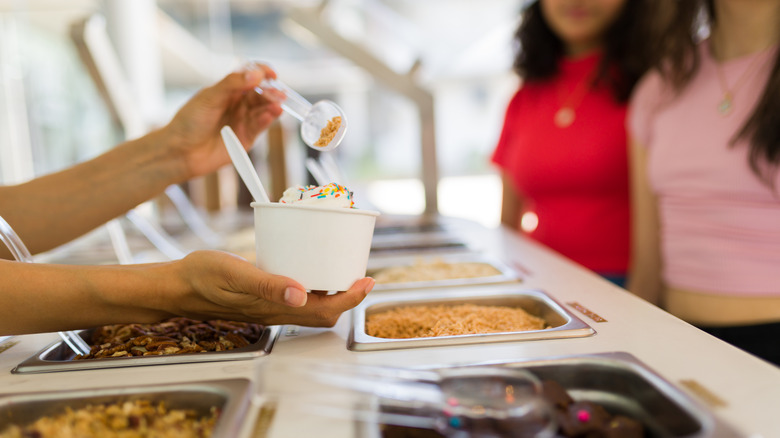 Vendor scooping ice cream for customers