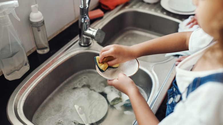 A child washing dishes
