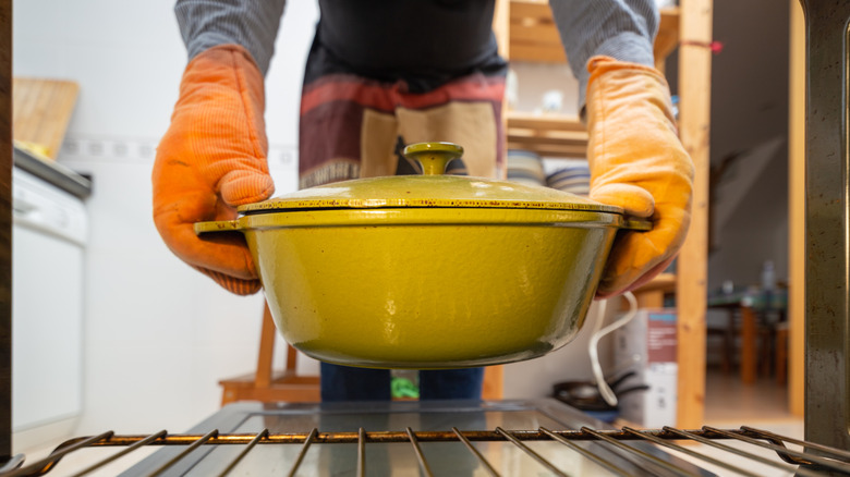 Person pulling casserole from oven