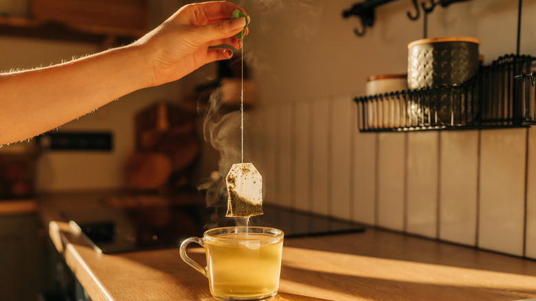A woman holds a mug of delicious freshly brewed tea in her hand