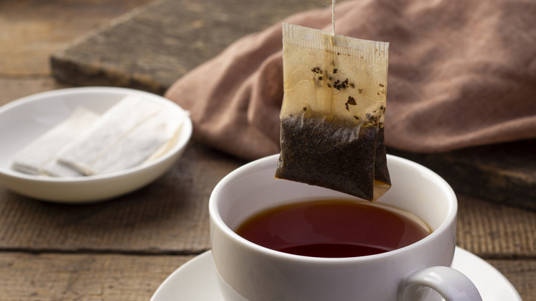 Tea bag with cup of tea