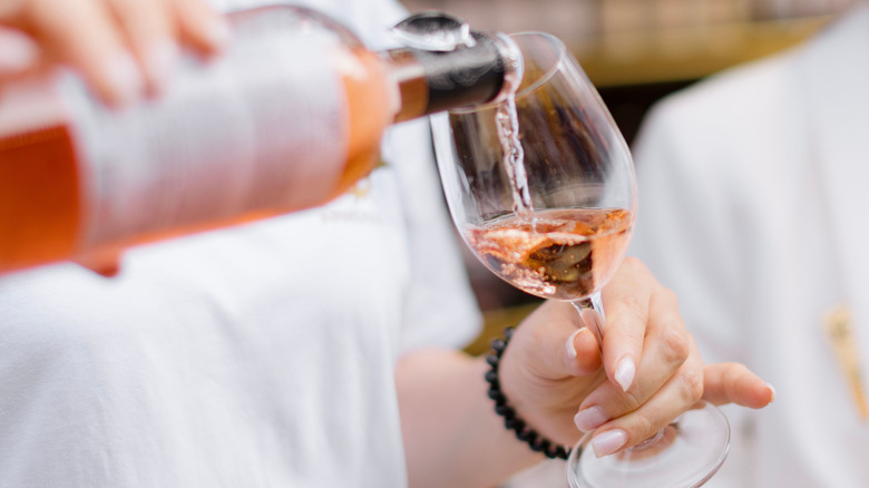 Person pouring rosé into a glass