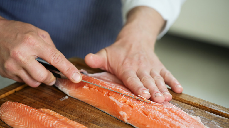chef filleting fish with a fillet knife