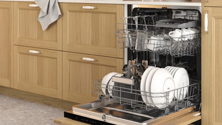 The Fornaboda built-in dishwasher fitted into a kitchen and shown filled with dishes