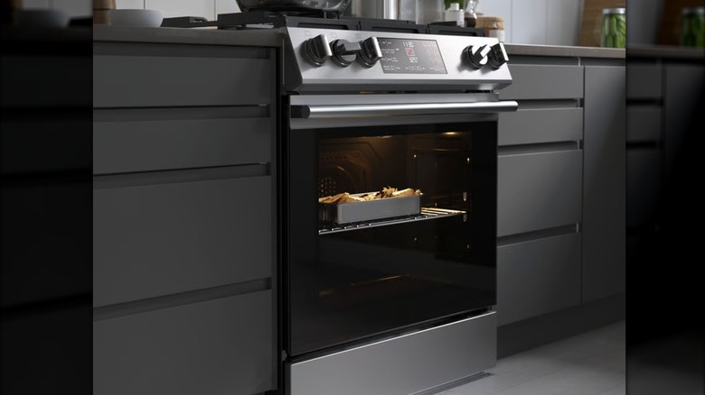 The Snesslinge range with a gas cooktop shown fitted into a kitchen with food cooking inside