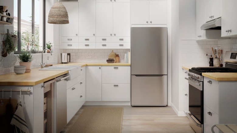 The Välgrundad bottom-freezer refrigerator shown in a wide shot of a modern kitchen
