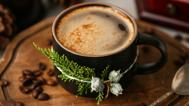 Coffee mug with a juniper branch tied around it