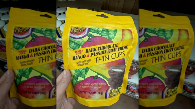 Someone holding a bag of Dark Chocolate Mango & Passion Fruit Creme Thin Cups