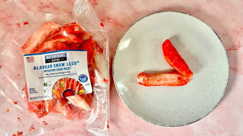 Package of Waterfront Bistro Alaskan imitation crab next to imitation crab on white plate