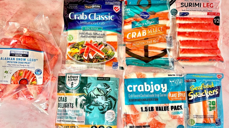 Seven packages of imitation crab on pink marble surface