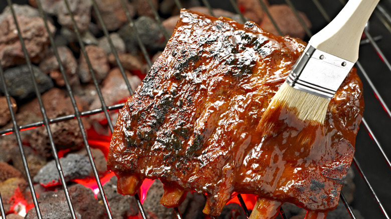 Person brushing glaze pork ribs