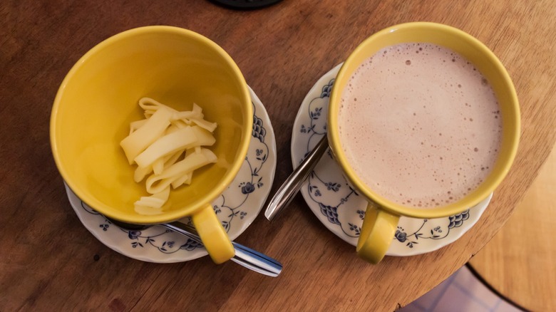 Yellow mugs with cheese and hot chocolate