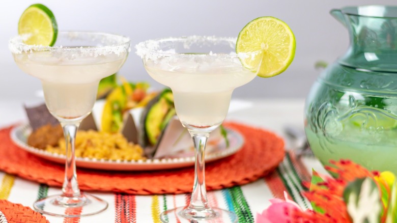 Traditional margaritas and pitcher in front of tacos