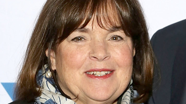 Ina Garten smiles with pearl earrings and a blue and white scarf