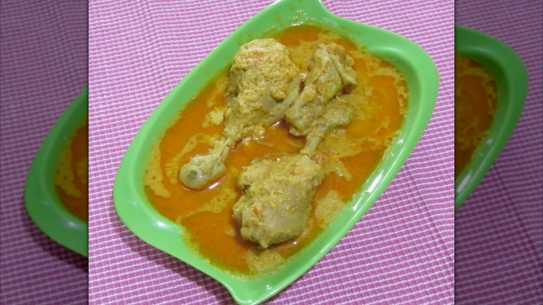 Several pieces of chicken served in gravy in shallow dish