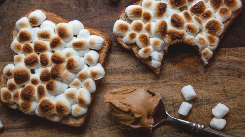 spoon of peanut butter next to slices of toasted marshmallow peanut butter toast